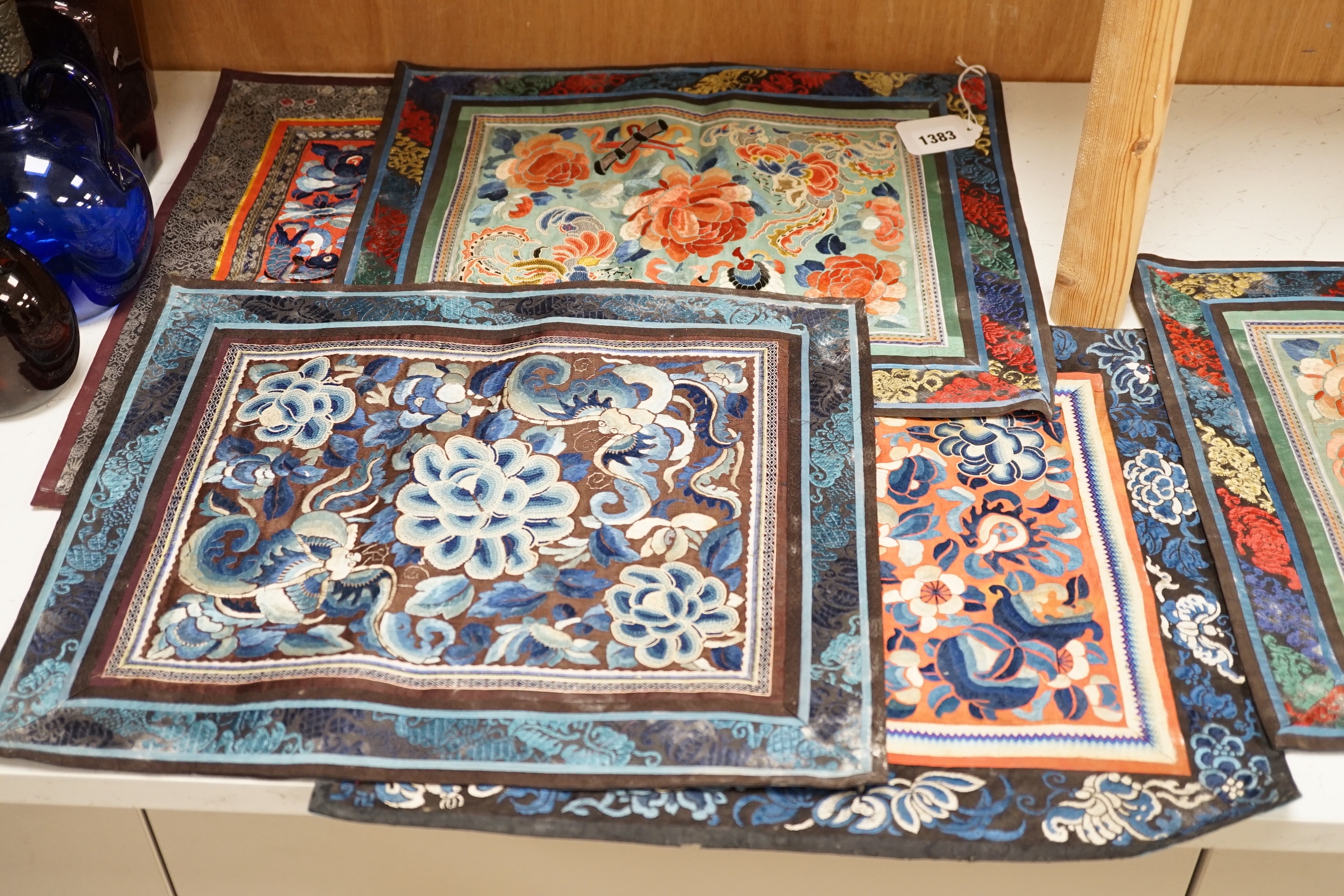 Six panels of Chinese silk embroidered mats, all using mixed stitches including Beijing knot, all bordered with silk brocade, largest 36 x 41cm